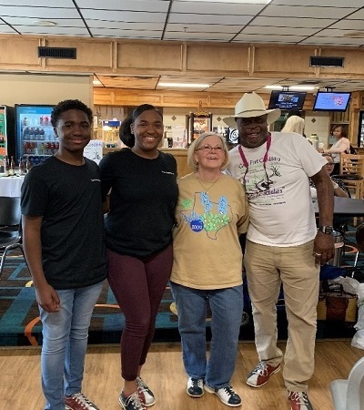 2 students and 2 adults posing for pic in bowling shoes