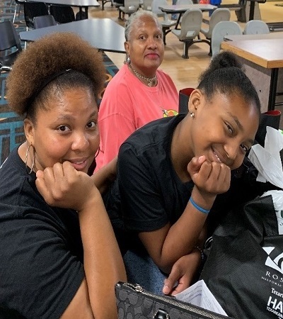 2 girls posing for picture by bowling lanes