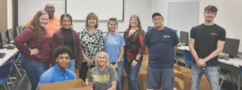 Red River Lumber Volunteers stand together with their arms around one another.