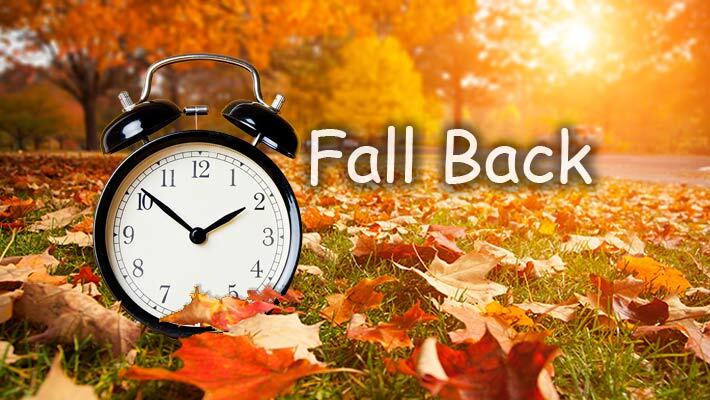 Fall Back. Alarm clock and autumn leaves.