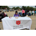 A woman sitting behind a table that reads &quot;The Salvation Army, Doing the Most Good&quot;