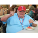 Man giving a rock and roll sign and eating watermelon