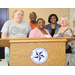 Group of people smiling behind a podium