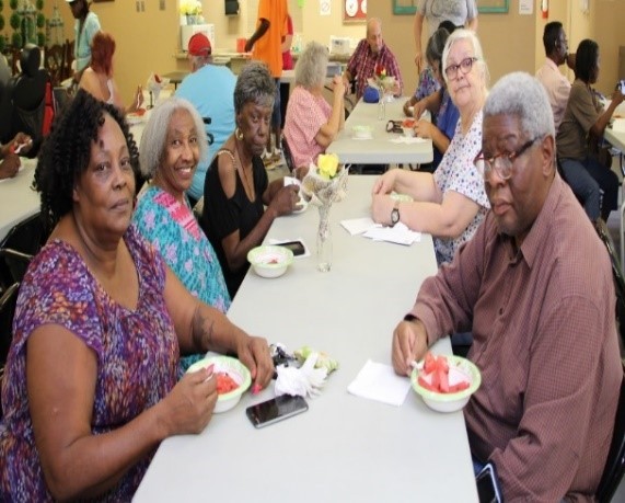 group of residents eating watermelon at a table