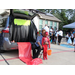 A woman and a child sitting behind a car with the trunk open