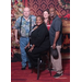 4 people posing in front of holiday backdrop with fireplace and Christmas tree