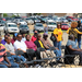 Men and women sitting in folding chairs outside watching