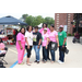 7 women smiling for camera together, in pink shirts