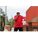 man in red shirt holding mic on stage