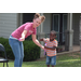 A woman helping a boy blow bubbles