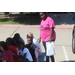 A woman standing behind a group of children smiling