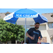 a man standing under an umbrella that reads &quot;ice cream&quot;