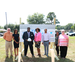 Mr. Williams and a group of people posing with a hard hat