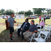 a man talking to two men sitting down