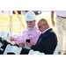 one man in a hard hat and one man in a suit sitting down