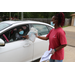 handing giftbag to guest in their car