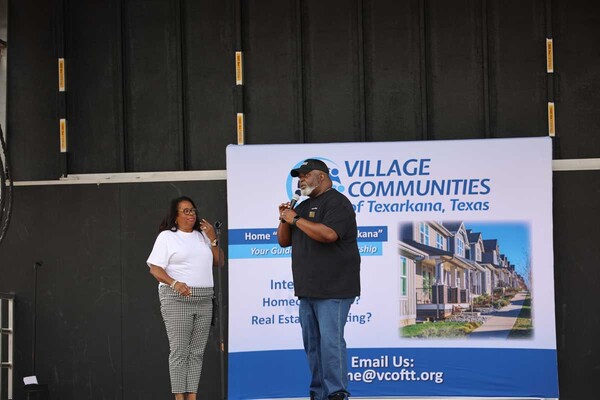  A man and woman talking on a stage.