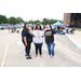 Three ladies posing in a parking lot. 