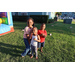 Three children standing beside a bounce house. 