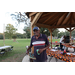 Gentlman at a gazebo holding a drink and a bingo card. 