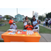 Group of people at a display table with bottle waters and tickets. 