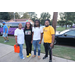 Four people posing on the sidewalk. 