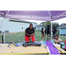 Man in a tent behind a DJ turntable. 