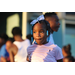 A young girl with a bow and beads in her hair. 