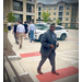  A man facing the camera while people are walking down the sidewalk. 