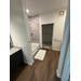  Partial view of the bathroom with an open door by the shower. 